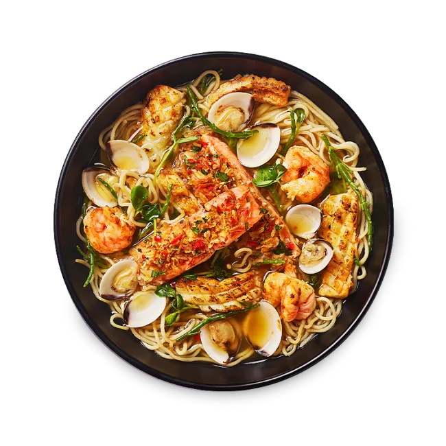 Wagamama signature seafood ramen, charred butterfly king prawns and tender squid, marinated in gochujang and miso, clams, salmon fillets topped with crispy onions and chilli