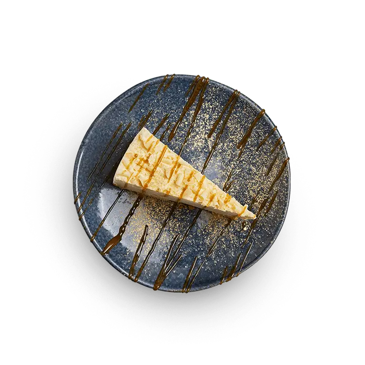 Wagamama white chocolate + ginger cheesecake, creamy cheesecake with a biscuit base and a zingy ginger twist, toffee sauce and ginger icing sugar